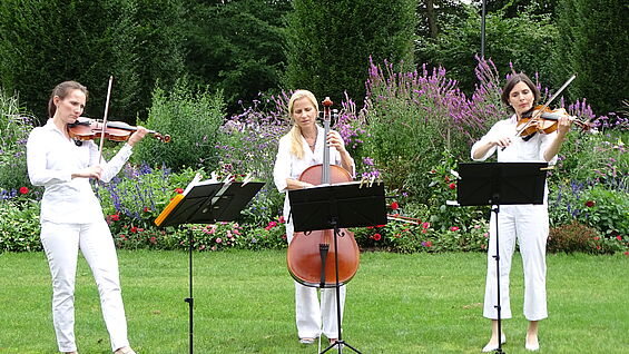 [Translate to Englisch:] Drei Musikerinnen in weiß gekleidet sind zu sehen.